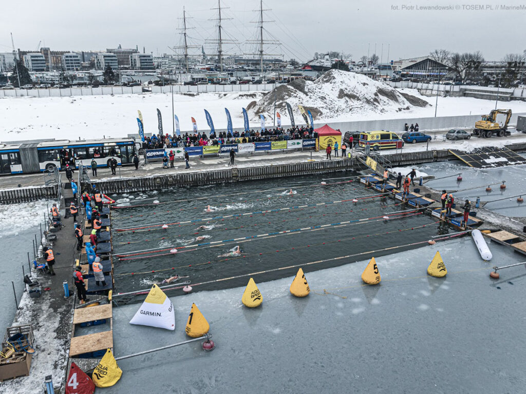Winter swimmers racing in an outdoor pool on the Baltic coast in Gdynia, Poland.